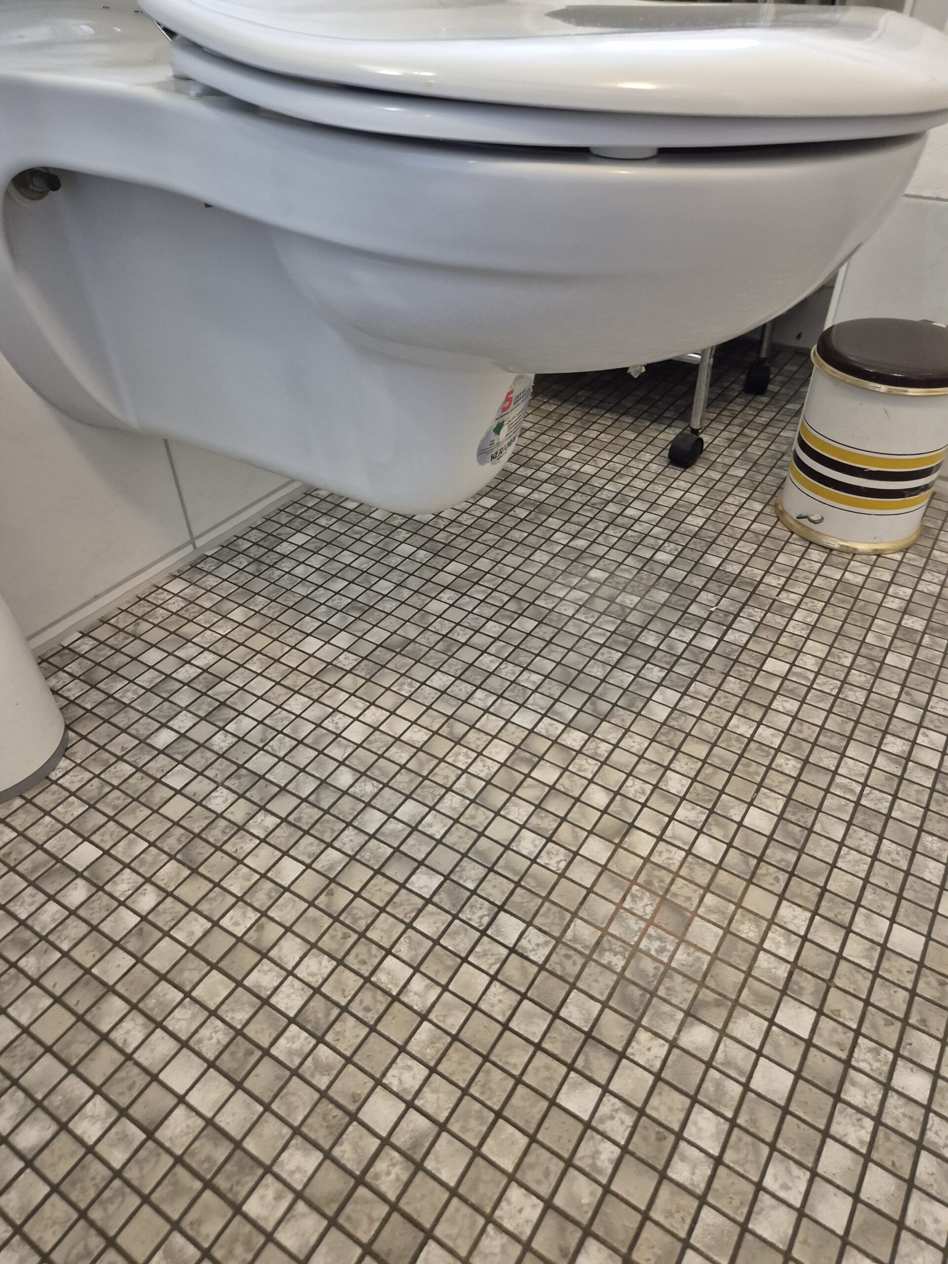 Wandtoilette über gefliestem Boden, ideal für einfache Gebäudereinigung.